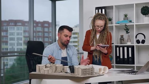 Architects Collaborate on Building Design in Bright Office