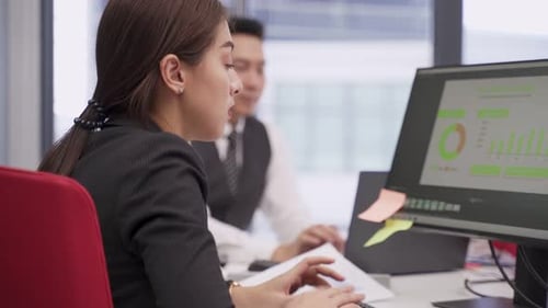 Asian young business man and woman typing on computer keyboard, working and plan as team in office.