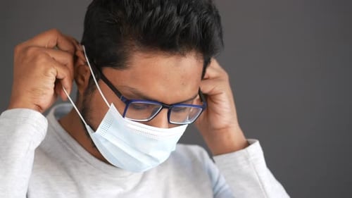 Young Adult Puts on Protective Face Mask