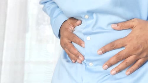 Young Man Suffering Stomach Pain Close Up.