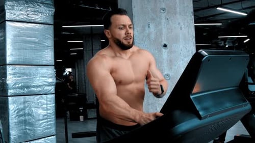 Muscular Man Working Out on Treadmill in Gym
