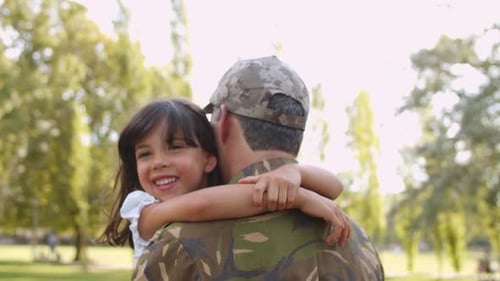 Child Embracing Person in Military Camouflage Uniform