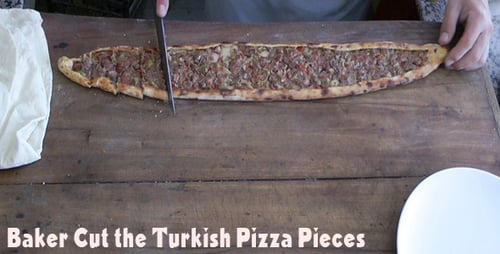 Food Worker Preparing Flatbread with Meat Topping