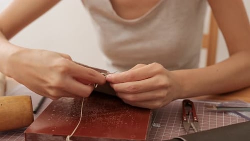 Artisan Handcrafting Leather Item with Needle and Thread