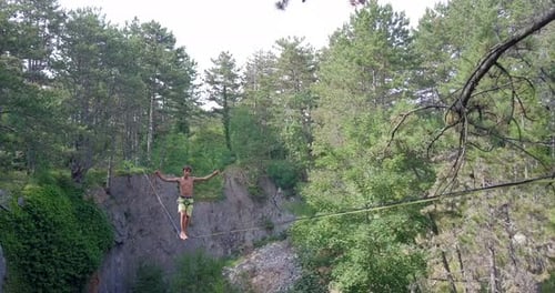 Young Adult Highlining Between Cliffs in Wilderness Area