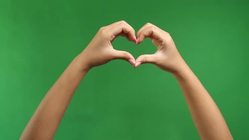 Female Hands In The Form Of Heart Isolated On Green Screen Background
