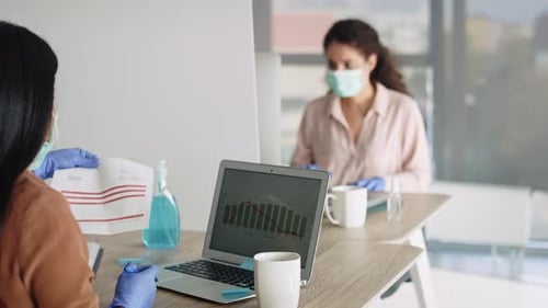 Adults working in modern office with COVID safety