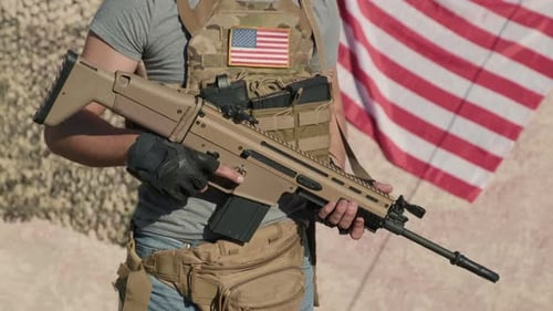 Man Holds Rifle with US Flag