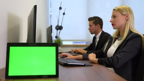 Two Office Workers, Man and Woman, Work on Computers