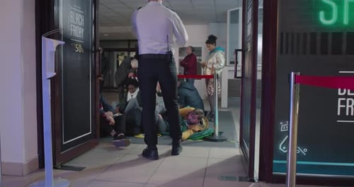 Waiting Crowd Running Past Guard in Mall