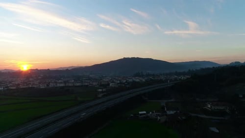 Cars Drive on Highway in Countryside at Sunset