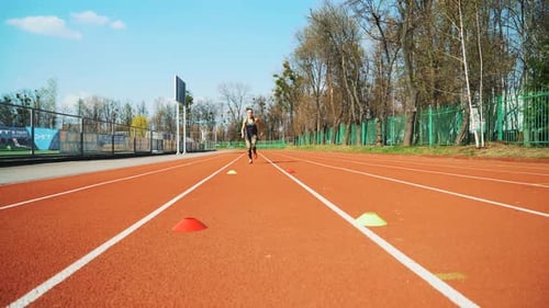 Young woman go in for sport run at the stadium track in the morning