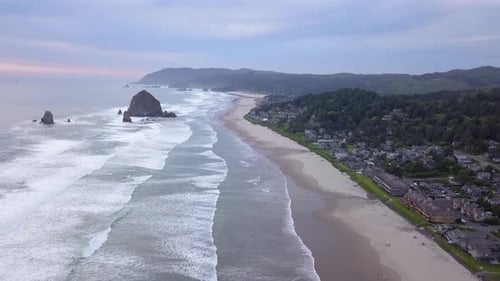 Aerial flying above the beach in Cannon Beach in Oregon, Haystack Rock