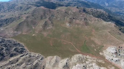 Spärliche Bäume Bewaldete Berge und kleine Wiese zwischen Tal