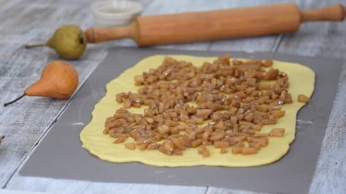 Girl Is Preparing a Cinnabon with Pear Filling. Sweet Homemade Pastry.