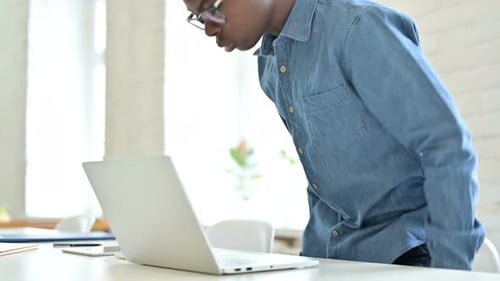 Young Adult Typing on Laptop at Bright Desk