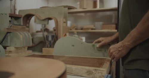 Senior Adult Craftsman Working on Guitar in Shop