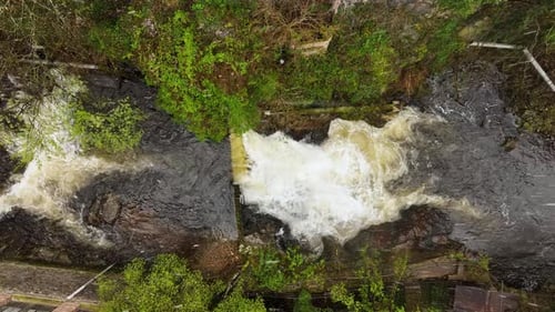 Waterfall on Mountain River with White Foamy Water Falling Down From Rocky Formation in Summer