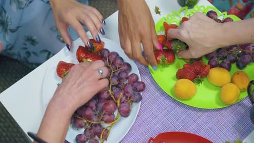 Women Hands Take Tasty Grape Strawberry and Peach on Plates