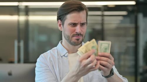 Man Counting Cash in the Office, Concerned