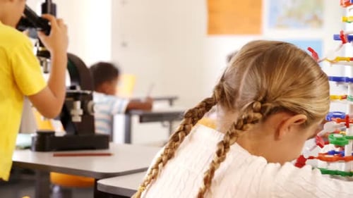 Children Exploring Science in Classroom with Microscope