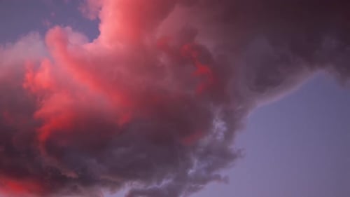 Colorful red lenticular clouds during sunset moving in the sky