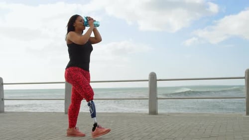 Side view of disabled woman drinking water on promenade 4k