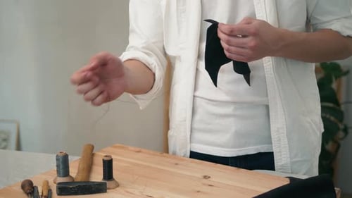 Retro-Lifestyle, Nahaufnahme, Handwerker, der mit Taschen oder Schuhen aus Naturleder arbeitet, kleine Unternehmen