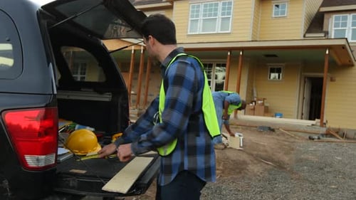Construction worker cutting siding