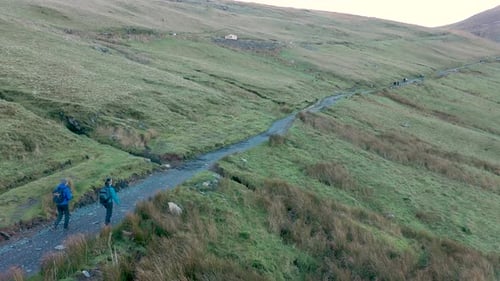 Aerial view of people hiking and climbing Snowdon mount in Wales on a sunny d