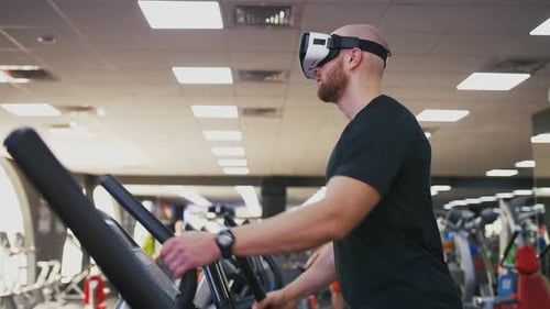 Young Strong Man Exercising on Treadmill at the Gym Wearing VR Glasses