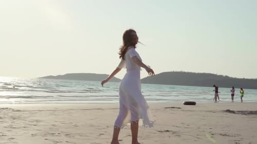 Beautiful female happy relax walking on beach near sea when sunset in evening.