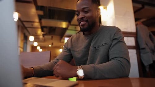 African American Man Is Satisfied with the Result of His Work on a Laptop