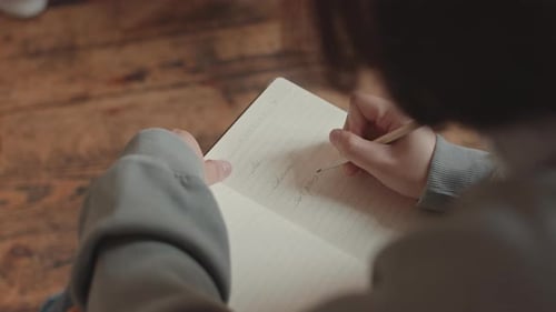 Student Taking Notes in Copybook