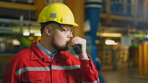 Industriearbeiter mit Walkietalkie-Steuerung arbeiten in einer Fabrik