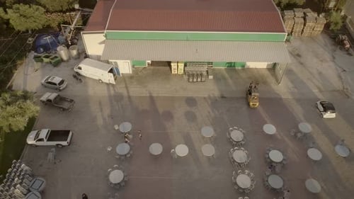 Aerial view of people preparing tables and chairs for a outdoor event in Greece.