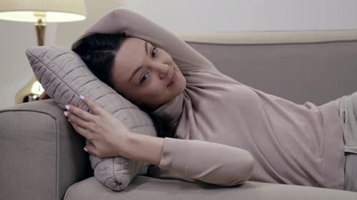 Woman Lying on Couch with Arm Behind Head