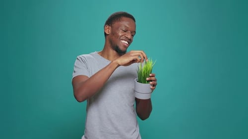 Cheerful Person Holding Pot with Houseplant in Studio