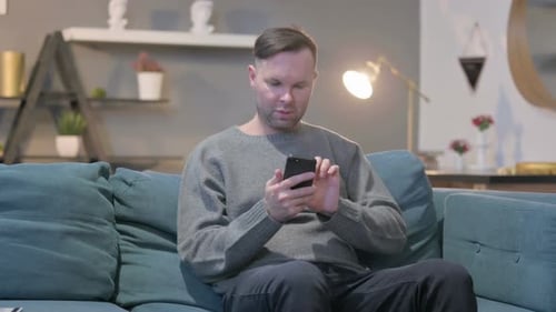 Man on Couch Using Mobile Device