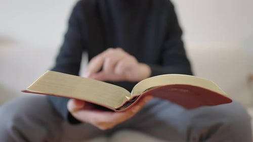 Person Sitting And Reading Old Book Indoors