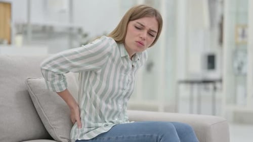 Tired Young Woman Having Back Pain at Home