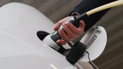 Man Plugging an Electric Car at the Electric Charging Station