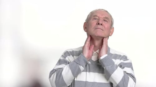 Senior Man Grips Throat in Discomfort
