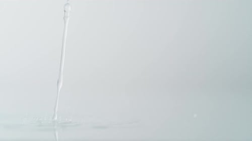 Hoja de col verde cayendo sobre la superficie del agua. Cámara lenta.