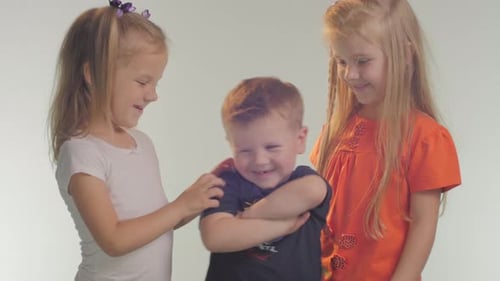 Three Smiling Children Standing Indoors Together