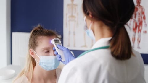 Doctor Takes Temperature of Patient With Thermometer
