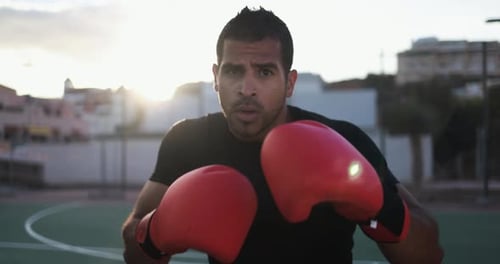Man Shadow Boxing on Urban Court at Sunset