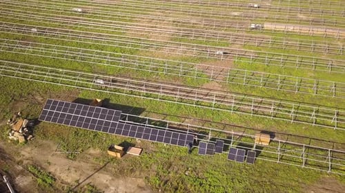 Aerial View of Solar Power Plant Under Construction on Green Field
