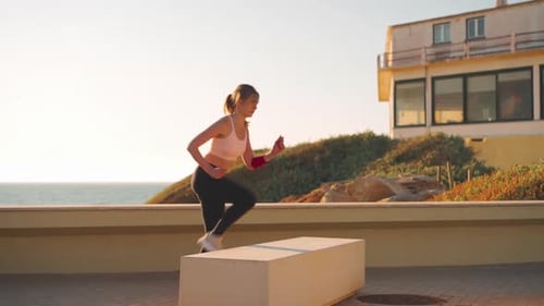Woman Exercising on Block by the Ocean