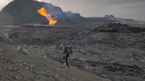 Photographer In Landscape With Lava Erupting From Fagradalsfjall Volcano